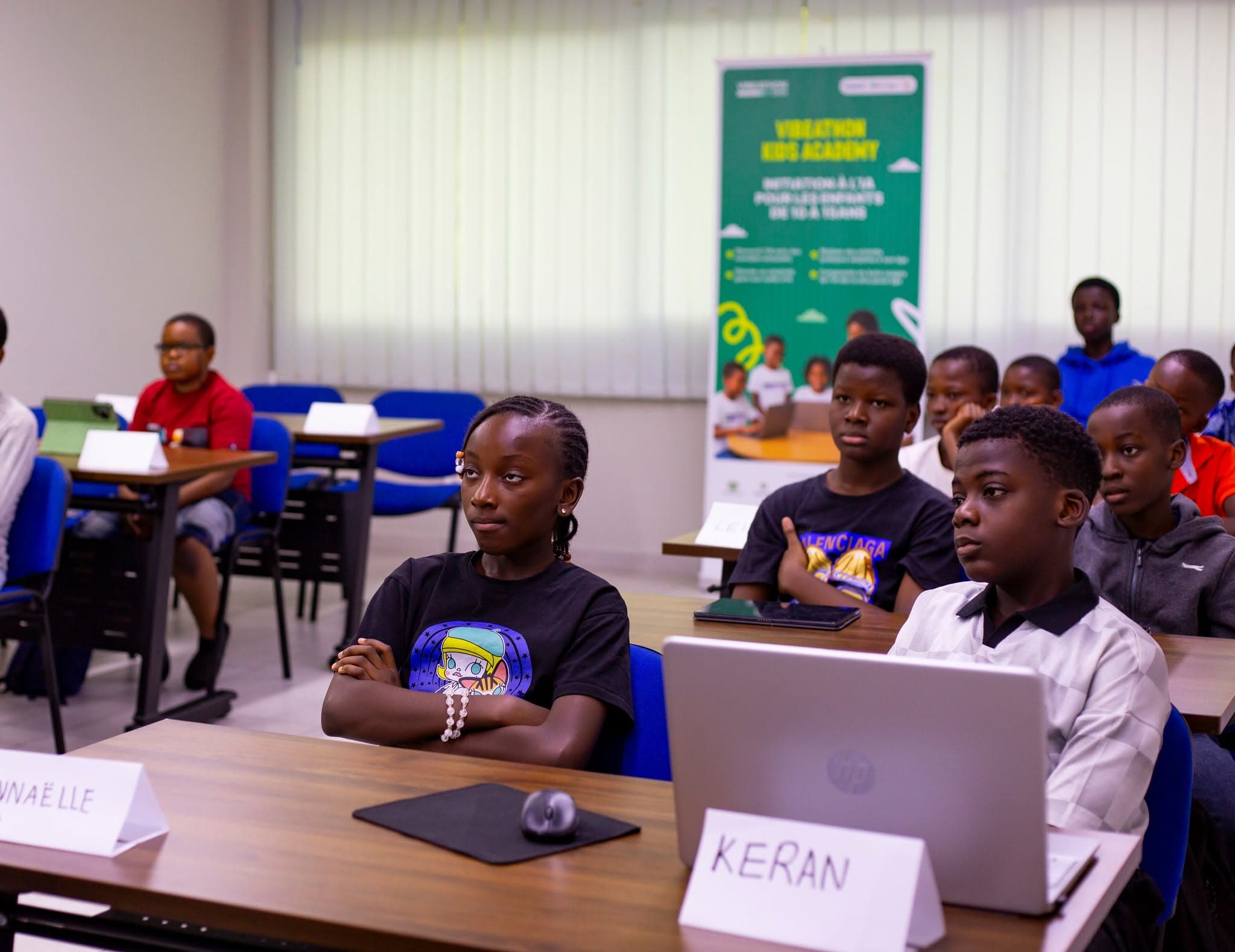 De jeunes participants de l'IA Kids Academy en atelier, ordinateurs ouverts